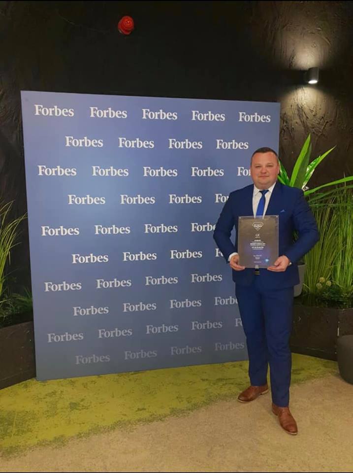 Businessman standing with Forbes Diamonds 2019 award for C2C sp. z o. o.