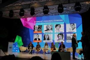 ctoc; eZaopatrzenie.pl; People discussing in front of LED display during ETI 2018 conference in Lublin.