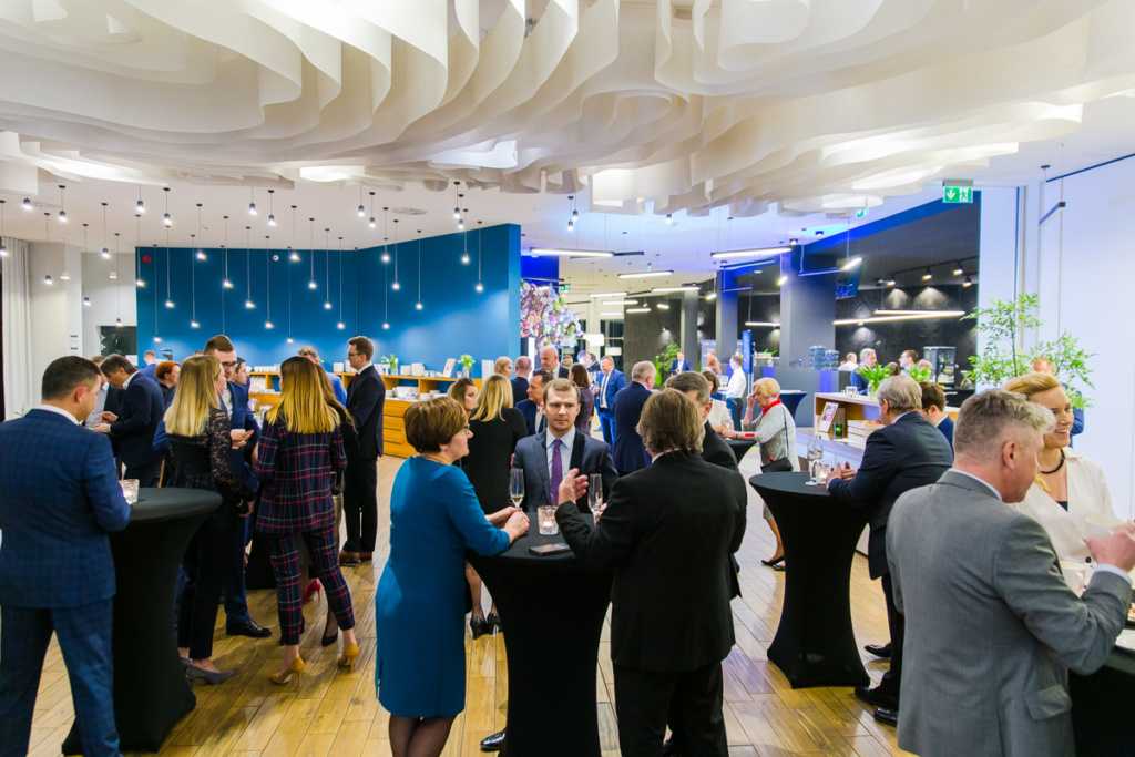 People wearing evening clothes standing and talking during gala.